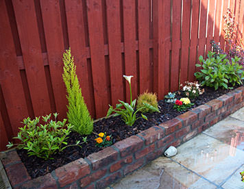 Raised reclaimed brick flower bed